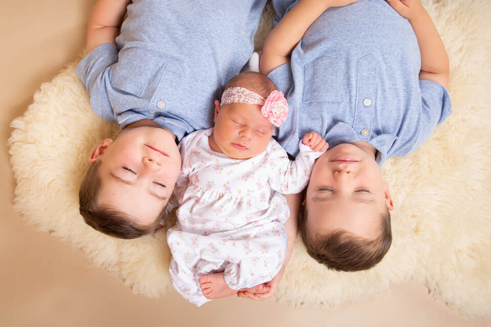 Newborn baby girl with big brothers