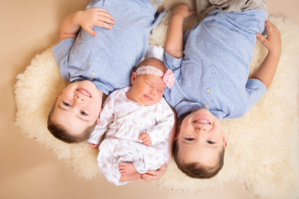 Newborn baby girl with two brothers