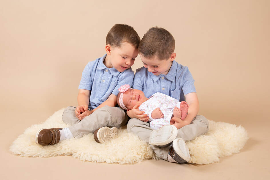 Newborn baby girl with brothers